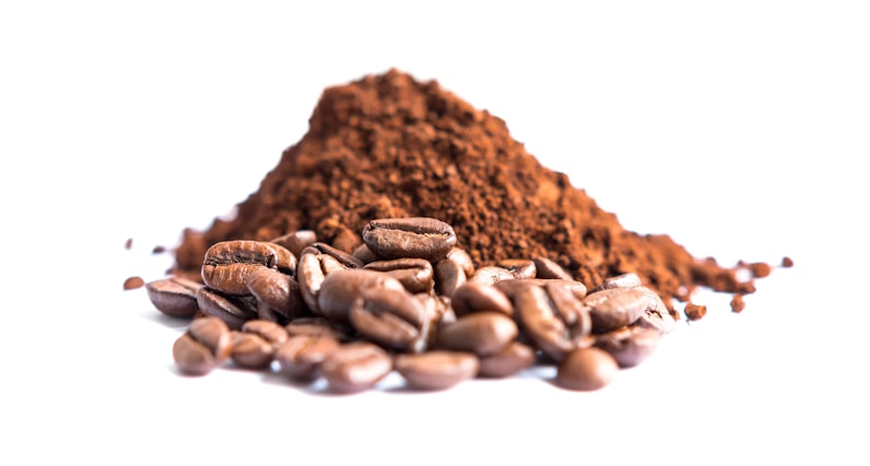 A pile of brown coffee beans is accompanied by a heap of finely ground coffee, creating a rich, textured contrast against the white background. The smooth, shiny surface of the beans adds a touch of glossiness to the composition.