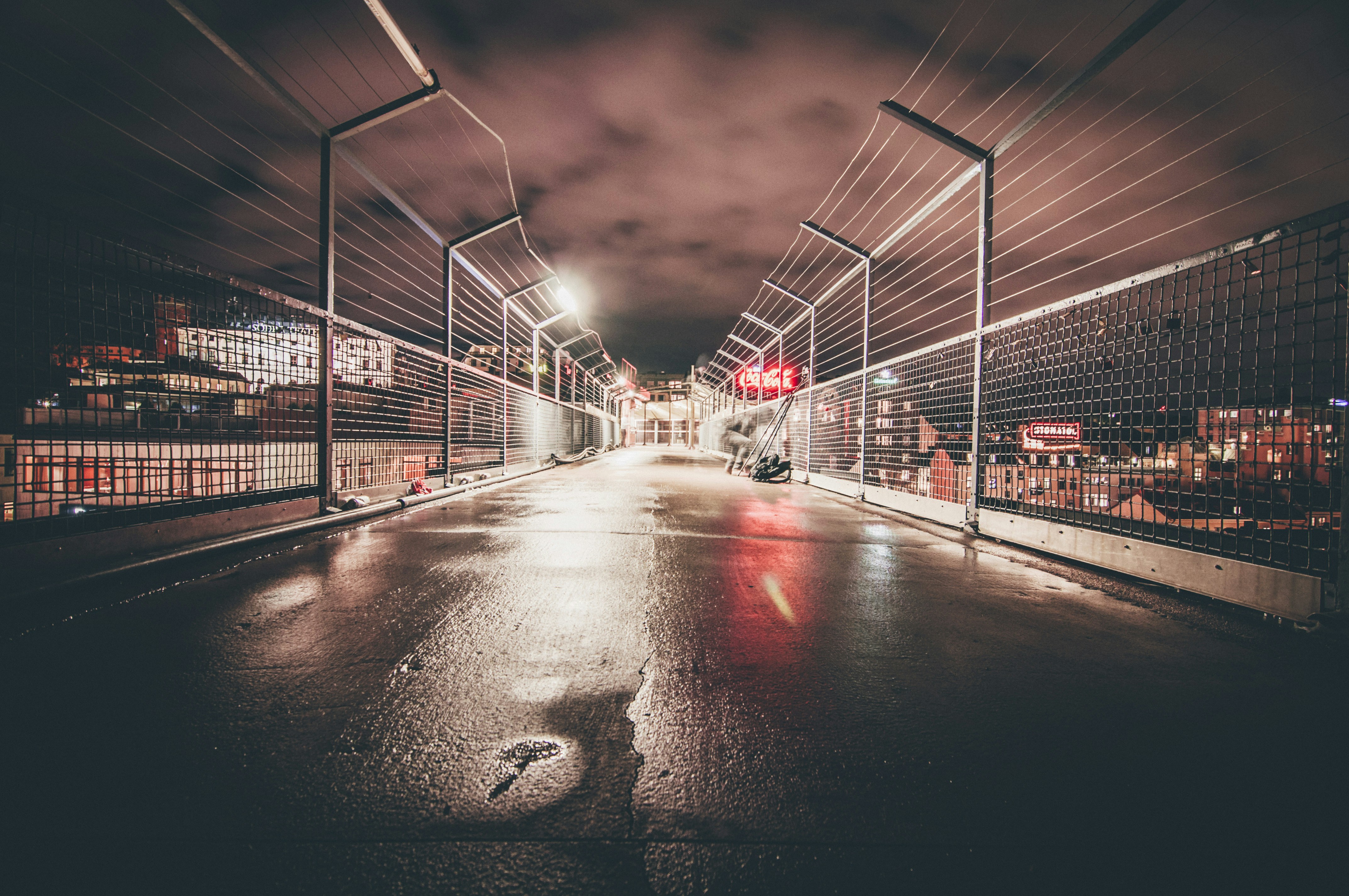 concrete pavement enclosed with chain fences at night time