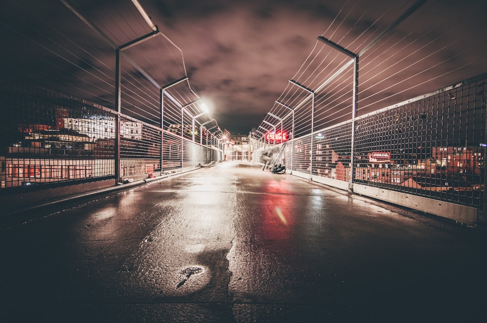 concrete pavement enclosed with chain fences at night time