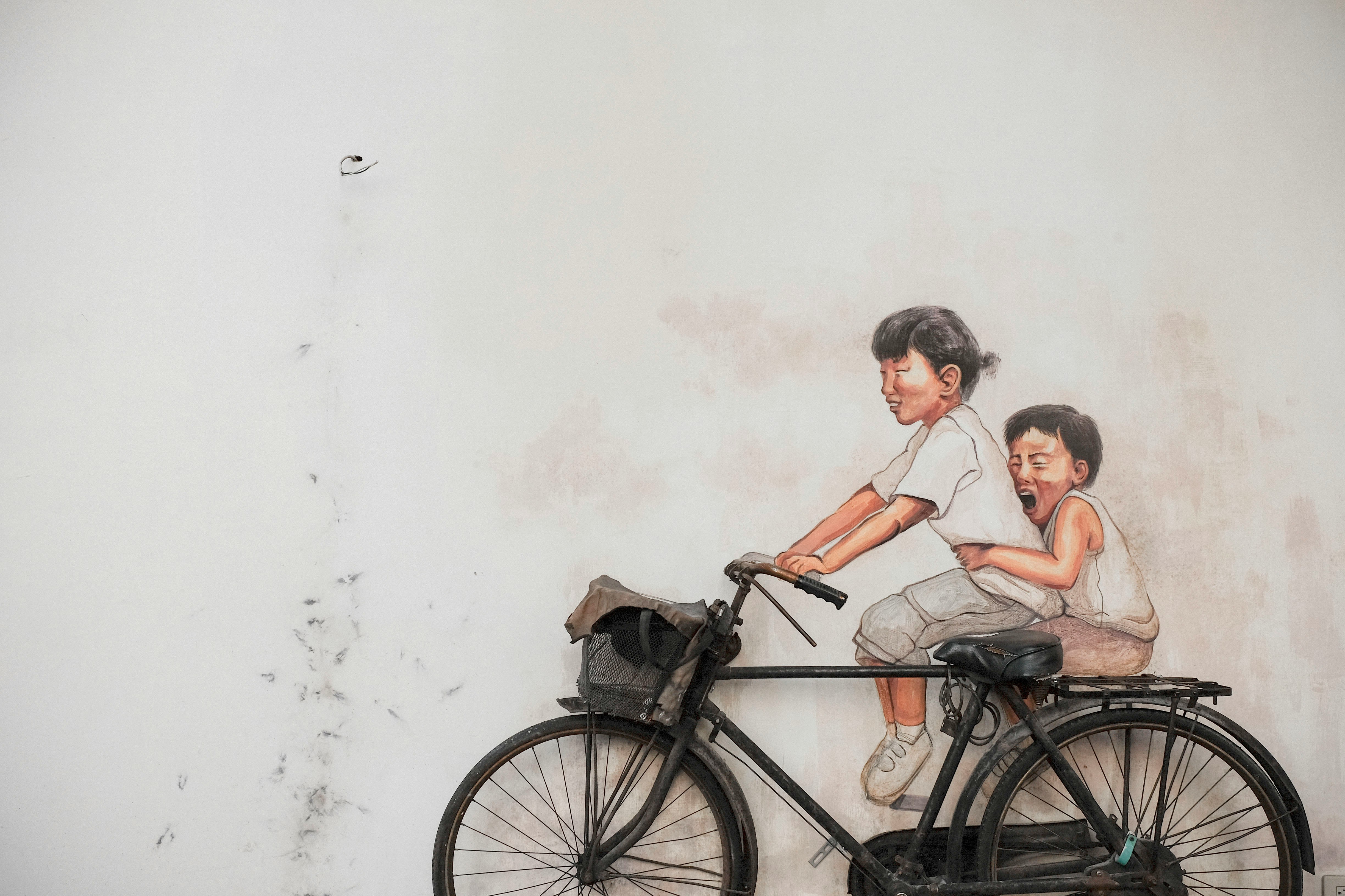 two children riding bicycle painting