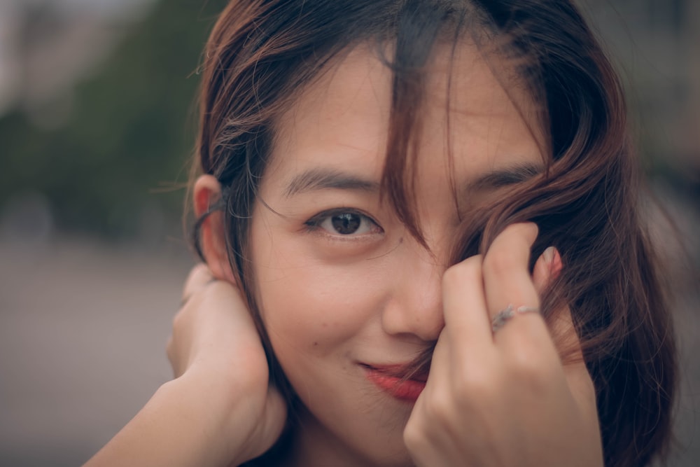 selective focus photography of woman covering her face