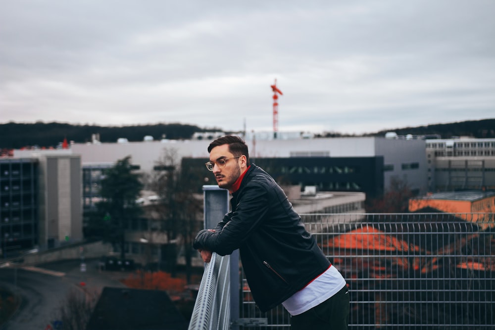 man standing besides railings