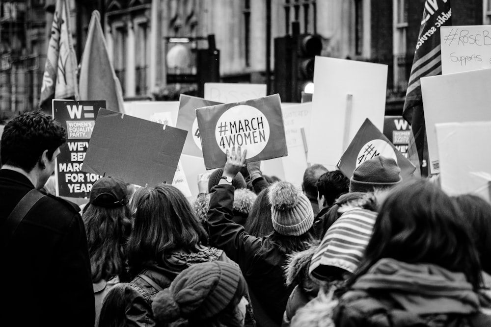 grayscale photo of group of people performing rally on street