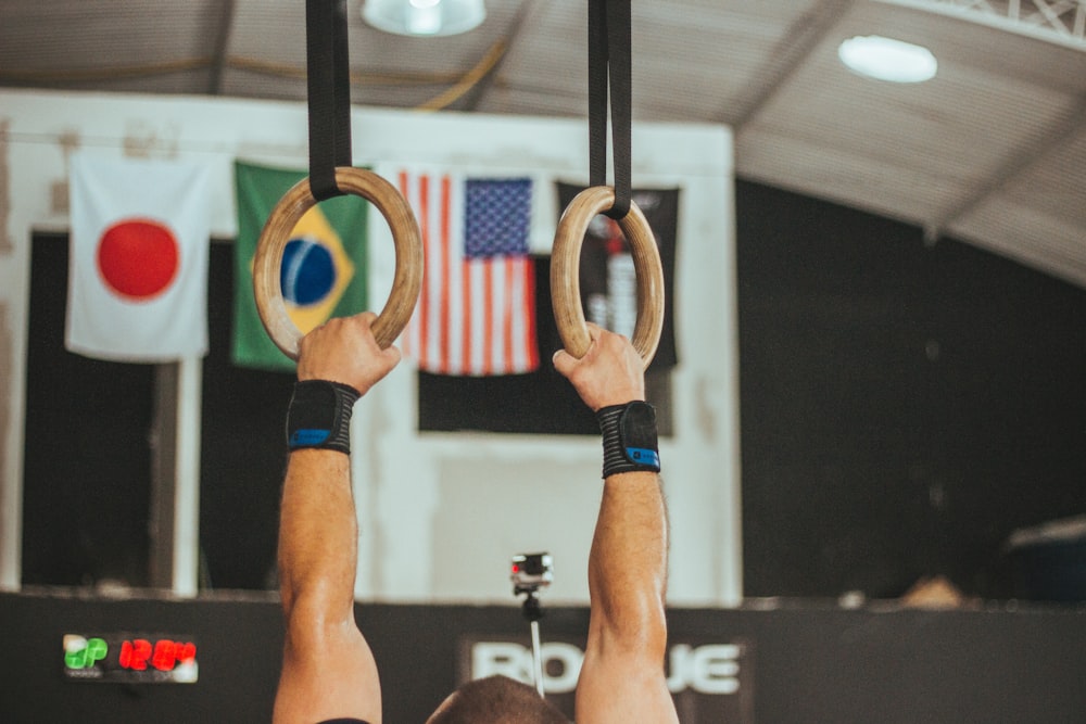 man holding two brown wooden rings