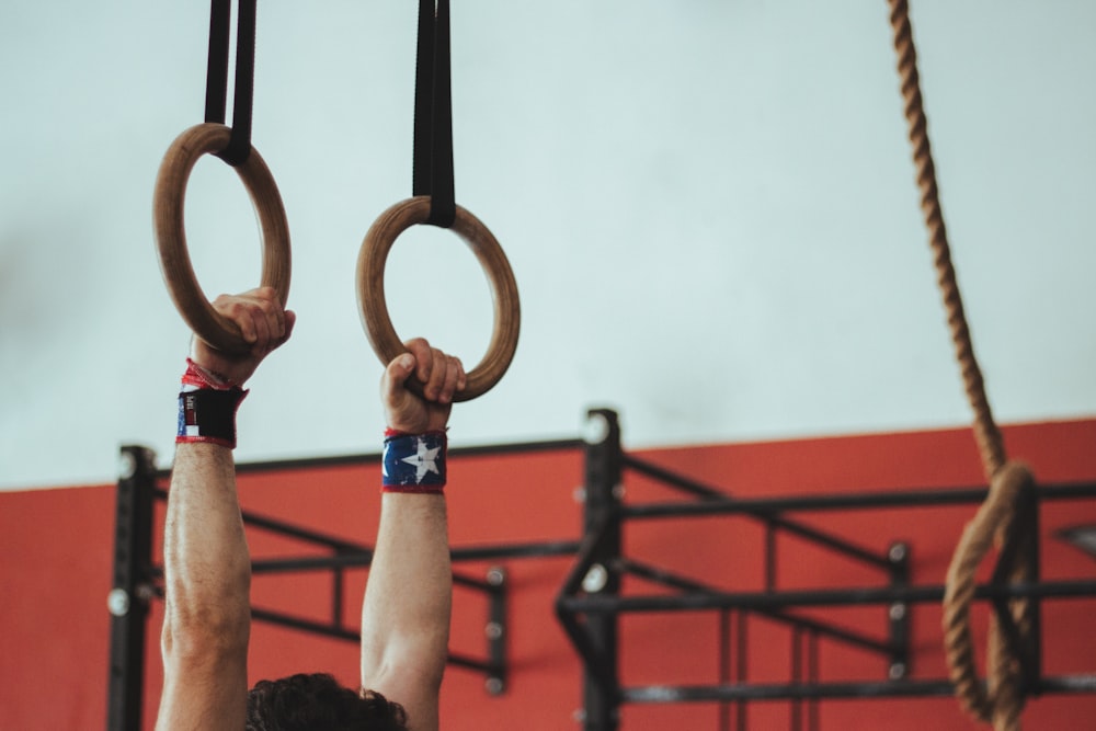 man hanged on brown rings