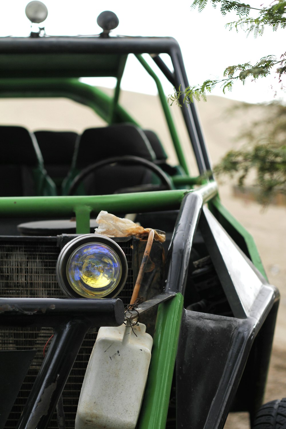 green and black dune buggy with dunes background