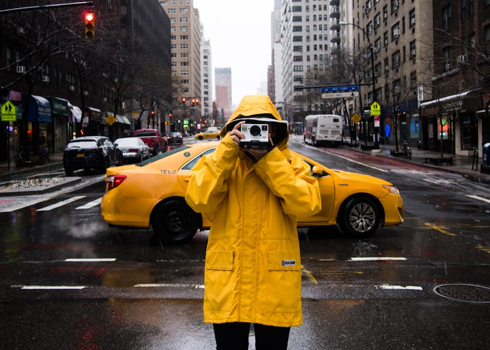 man standing on road while holding camera