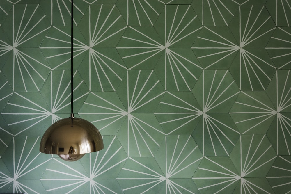 silver pendant lamp with a wallpaper covered wall