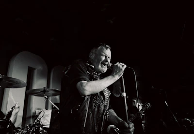 A warmly lit birthday party scene with Björn Bussler singing passionately to an engaged audience.