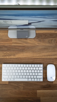 A modern desktop setup with a large monitor and wireless keyboard on a clean desk.