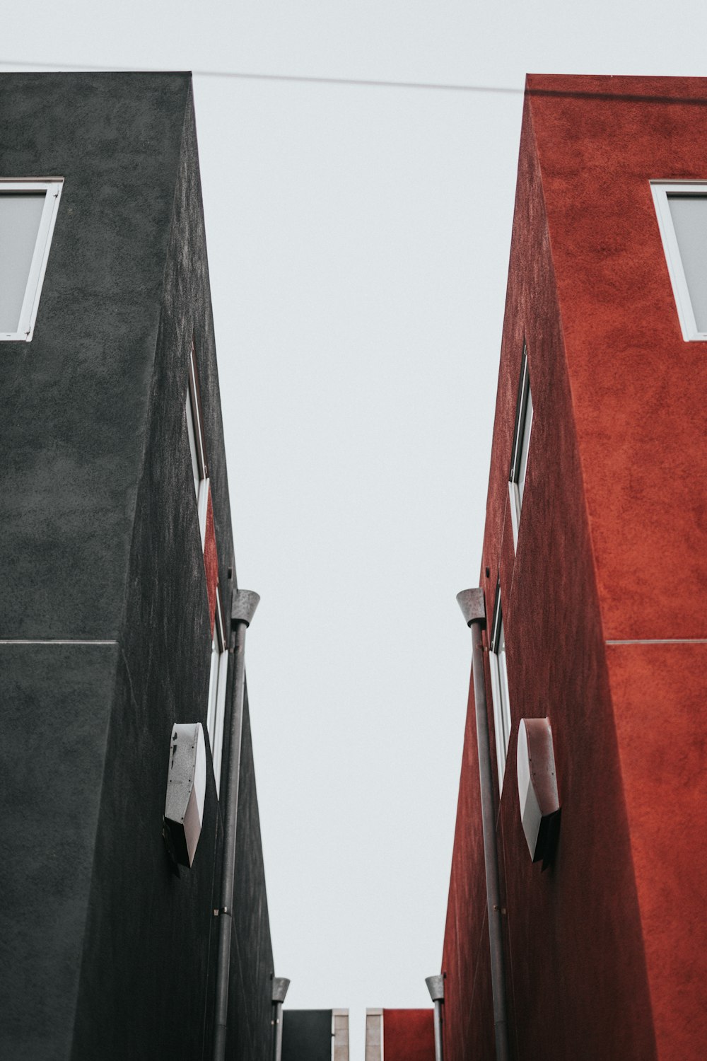low-angle photo of two black and red concrete buildings