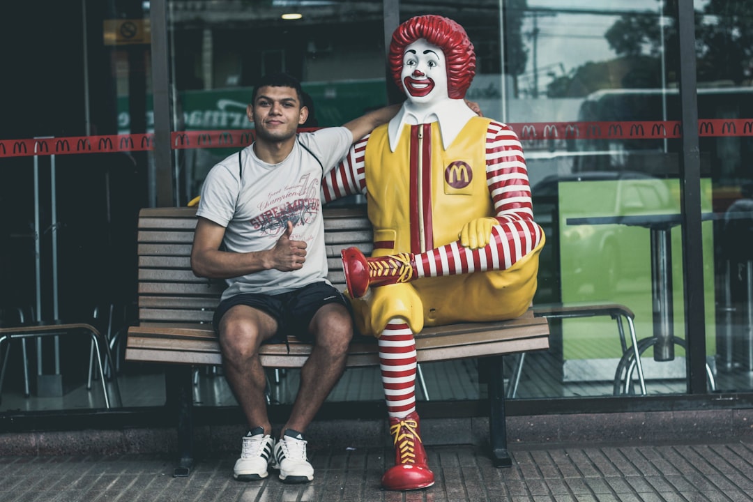 man sitting beside McDonald statue