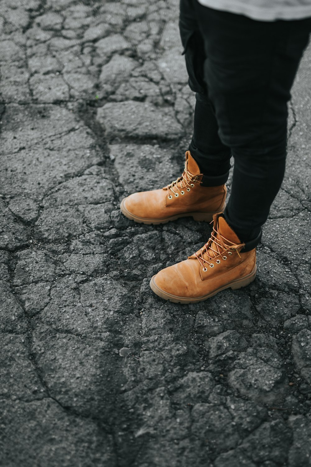 man standing on cracked gray concrete pavement during daytime