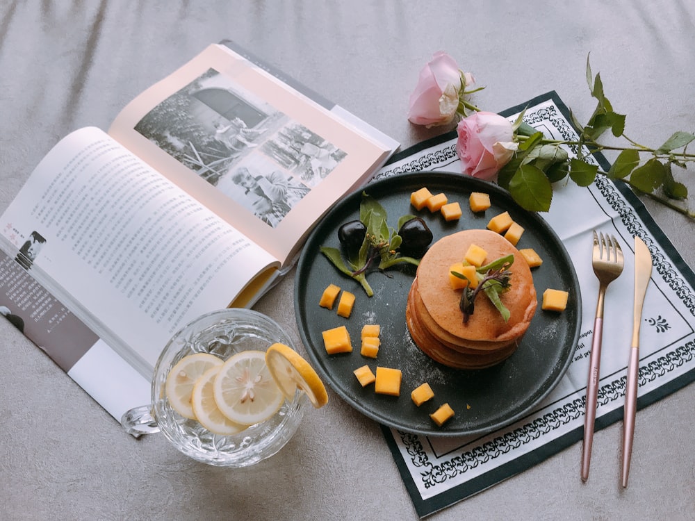 baked pastry on black plate near book