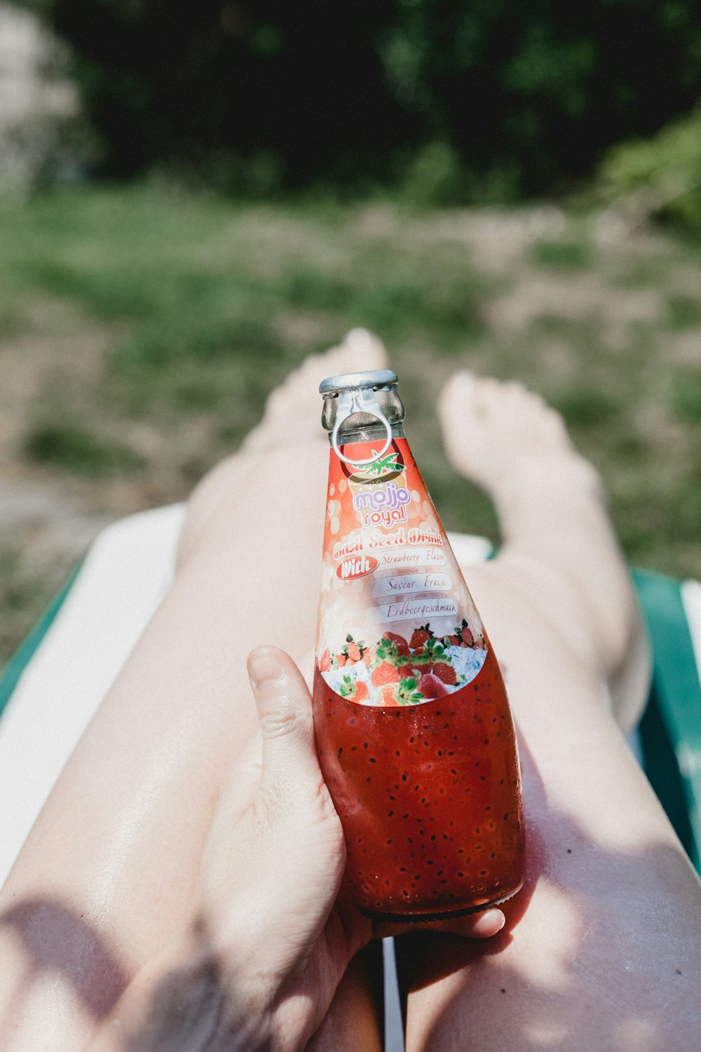 person holding red labeled glass bottle