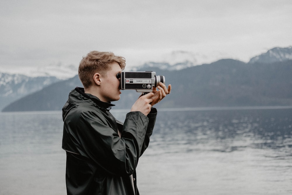 Hombre tomando video cerca del cuerpo de agua