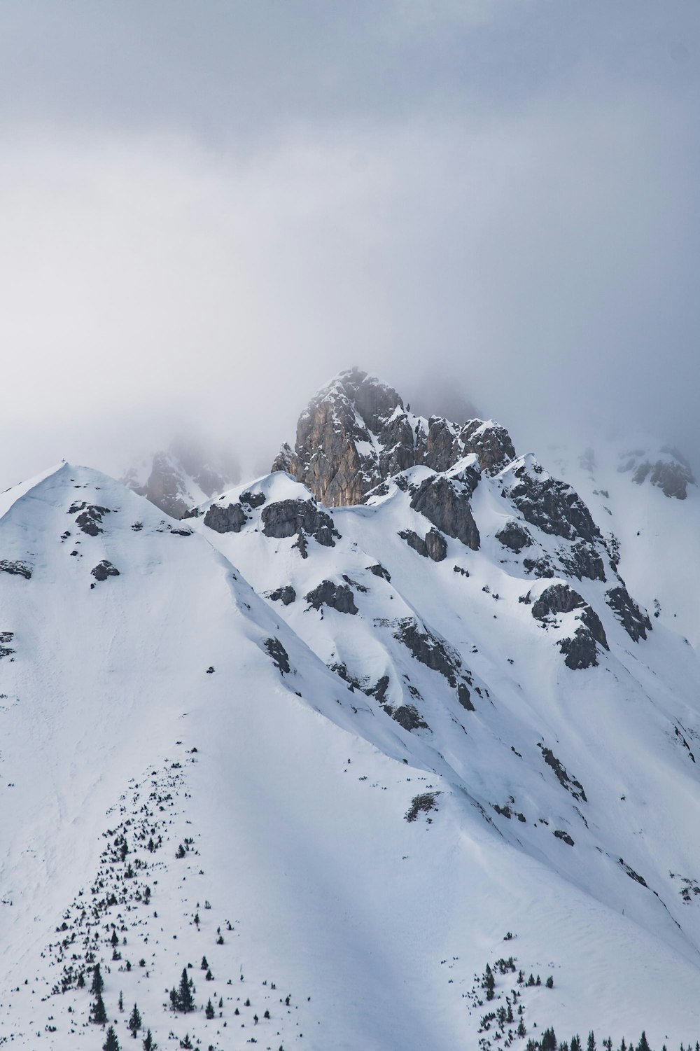 snow covered mountain under white clouds