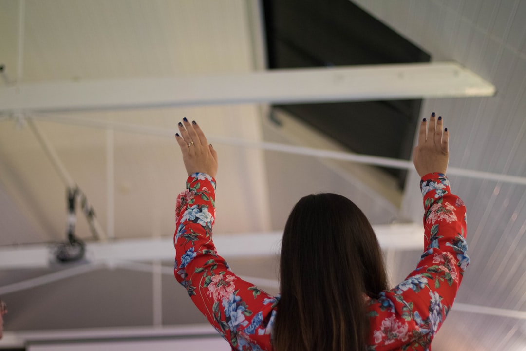 woman holding her hands up inside building structure