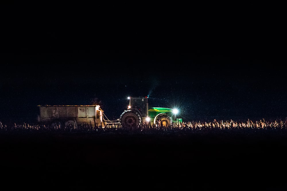 Camión de carga verde en tierra durante la noche
