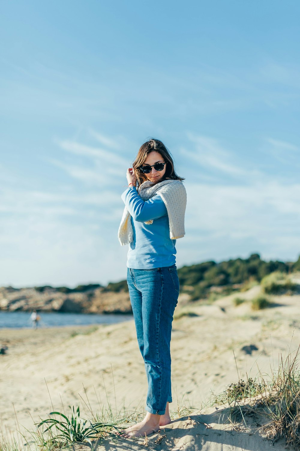 woman standing with bare foot on seashore during daytime