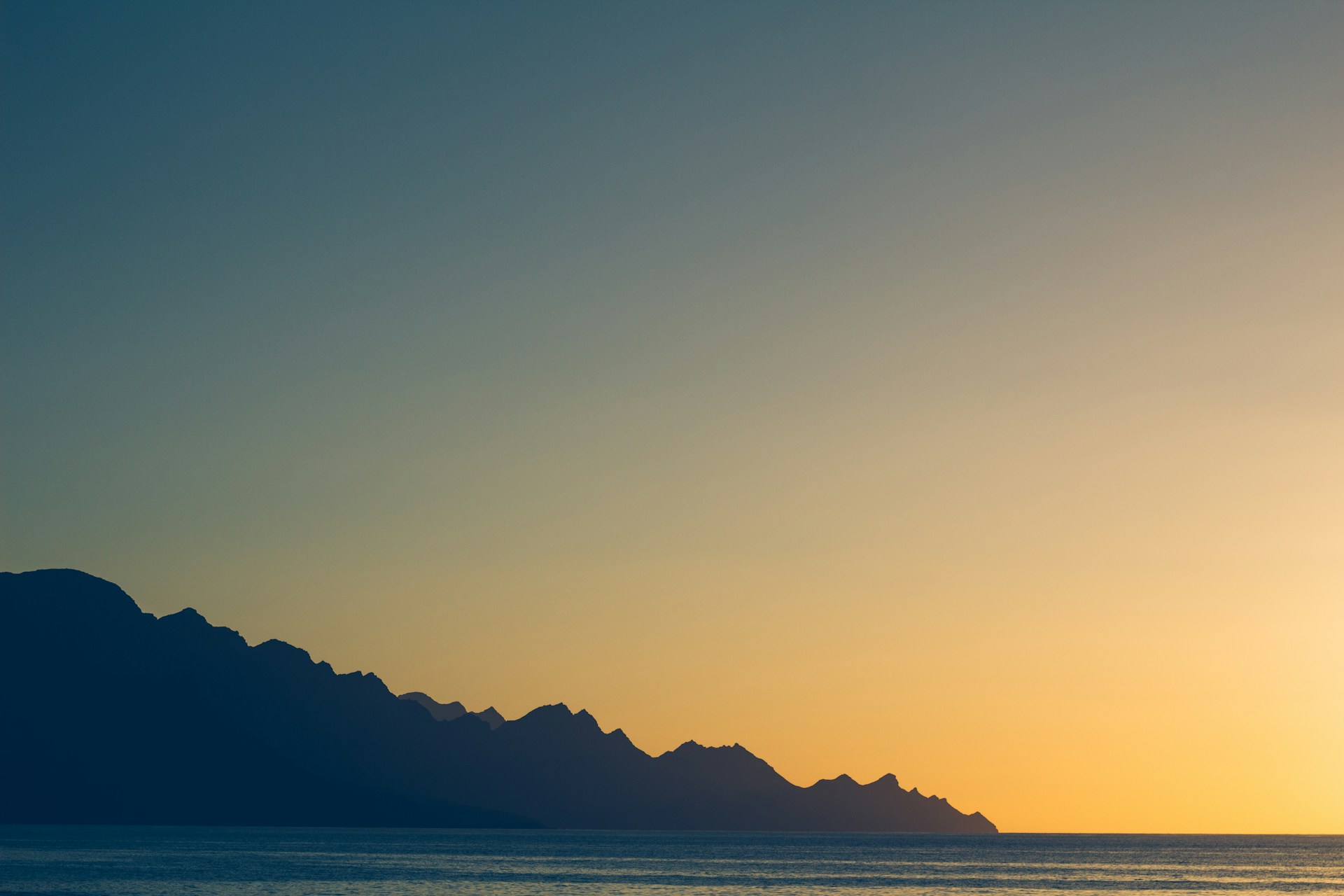 silhouette of mountain near body of water