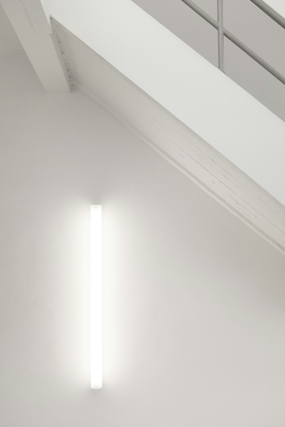 Une chambre blanche avec une lumière sur le mur