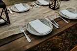A rustic dining table set with handmade placemats and linen napkins.
