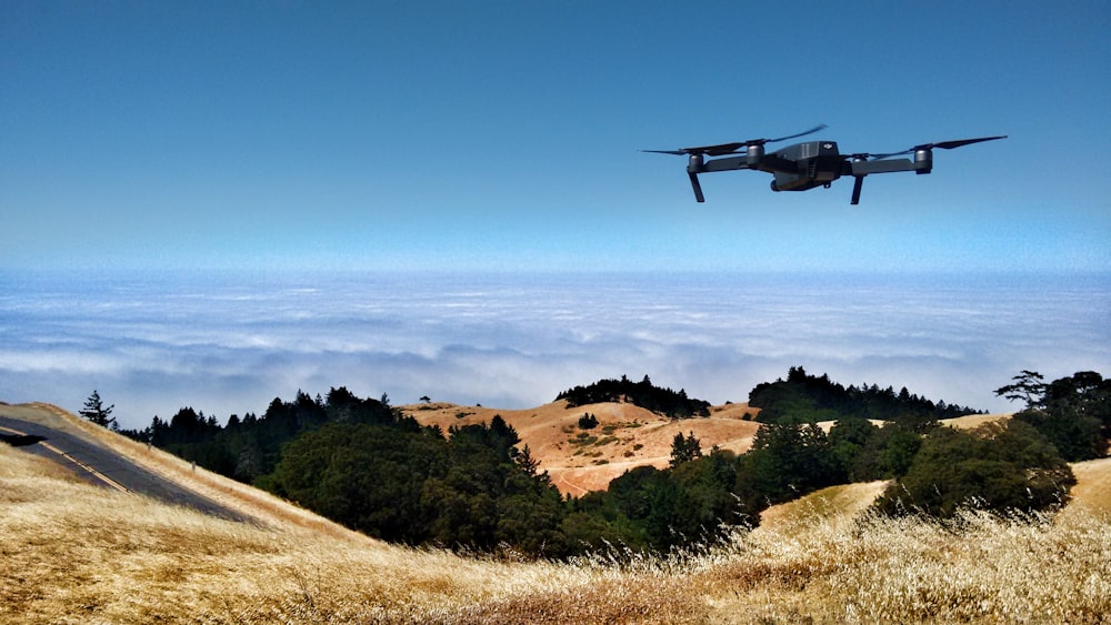 black drone on air over cloudy sky at daytime