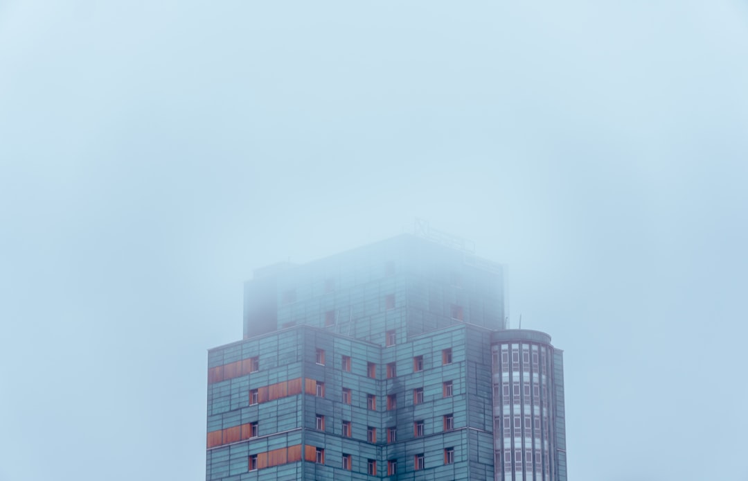 photo of white and blue building covered with clouds