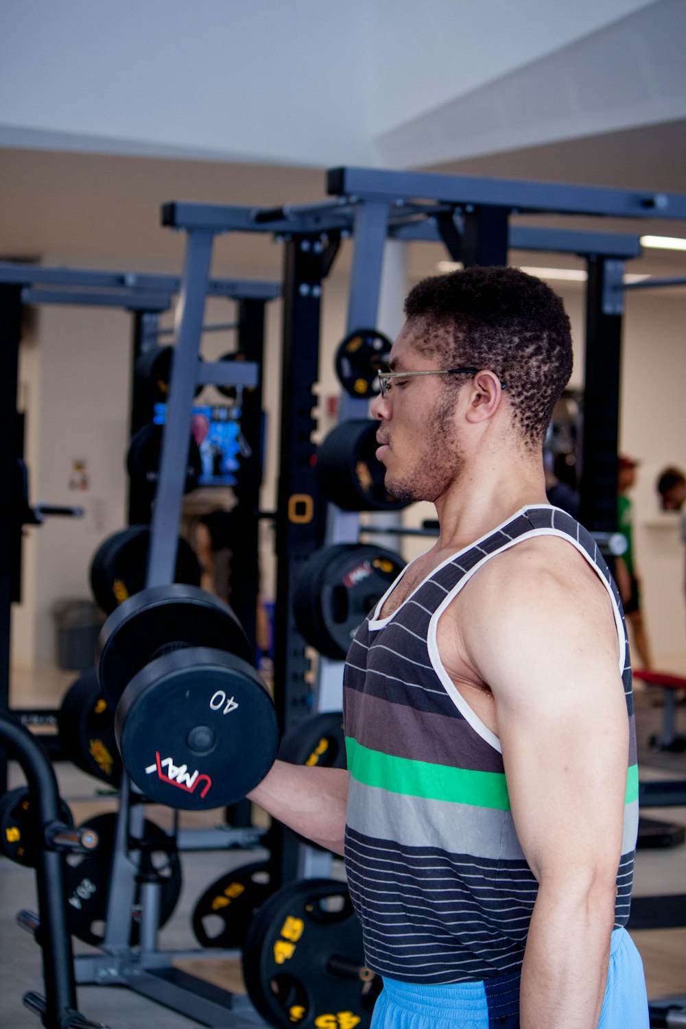 man lifting 40 LBS. dumbbell inside gym