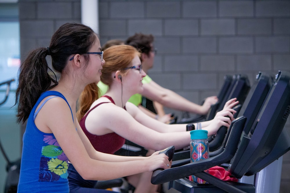 two woman walking on treadmills