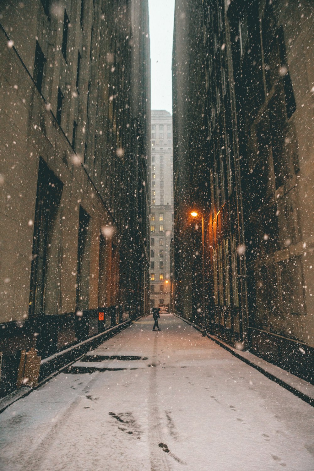 pessoa em pé entre edifícios altos marrons durante o dia