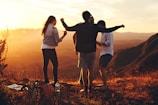 four people standing on edge of mountain