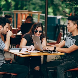 photo of three person sitting and talking