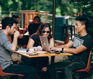 photo of three person sitting and talking