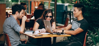 photo of three person sitting and talking