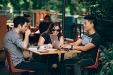 photo of three person sitting and talking