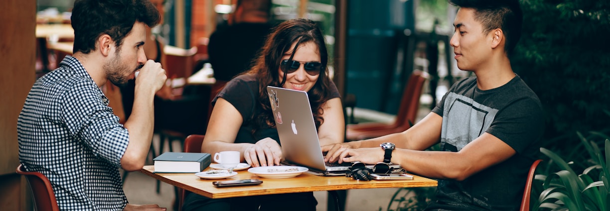 photo of three person sitting and talking