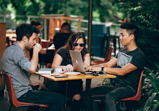 photo of three person sitting and talking