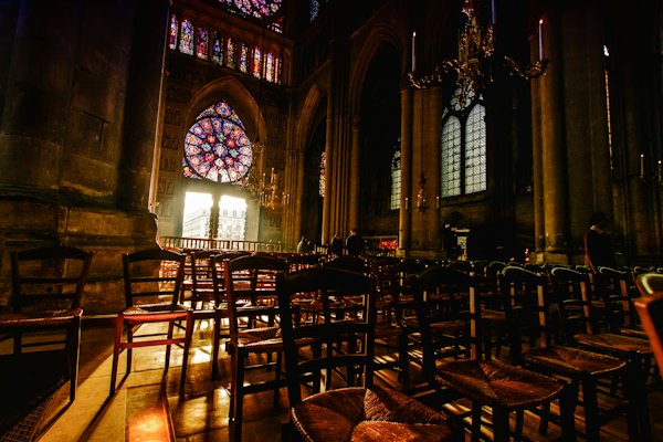 Inside the cathedral, the rose window above the chairs — Reims, France