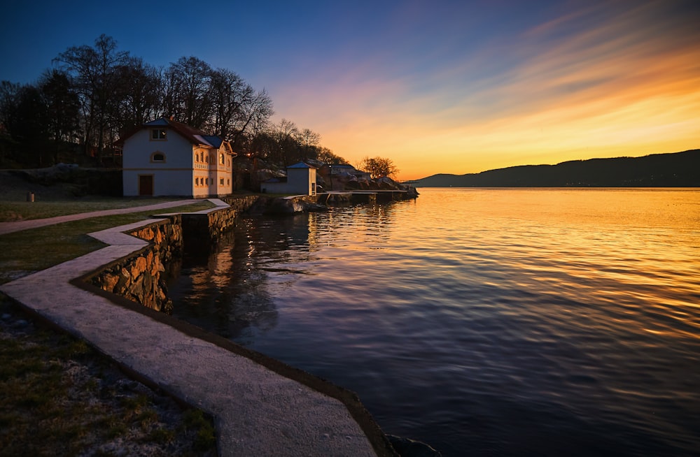 Photographie de paysage d’une maison avec un sentier près de la baie