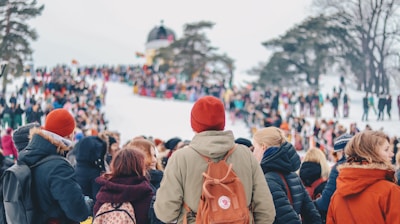 people standing on trees covered by snow under white clouds