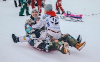 three persons riding on sled