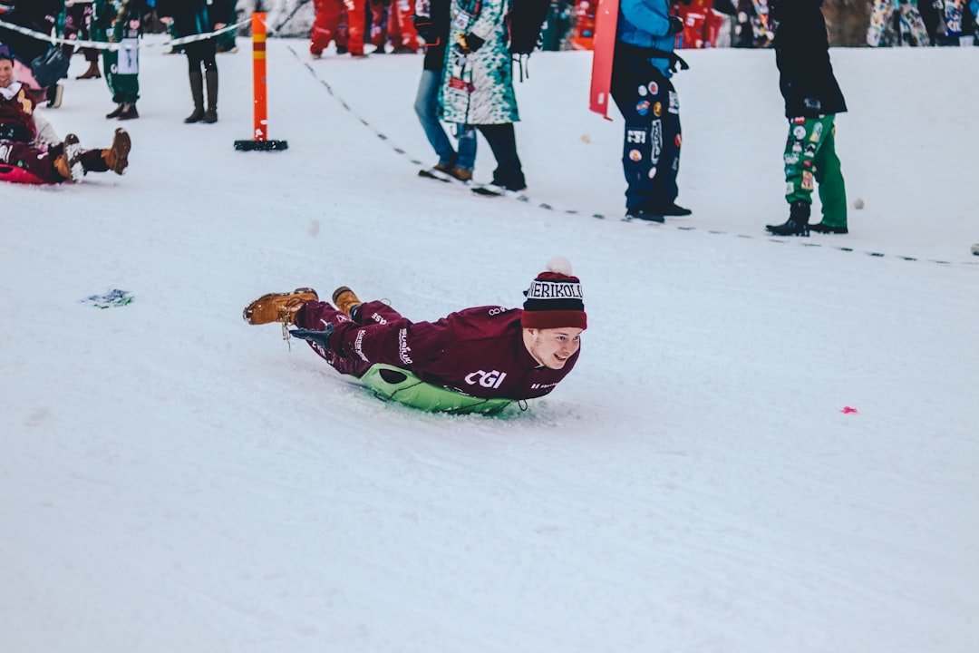 person riding green board on downhill during snowtime,