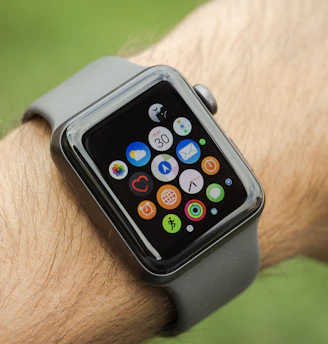 A smartwatch on a wrist displaying notifications against a blurred city background.
