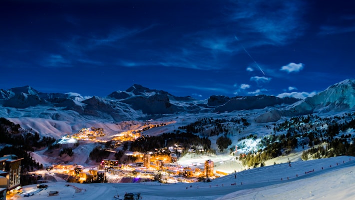 La Plagne village lit up at night beneath dark peaks