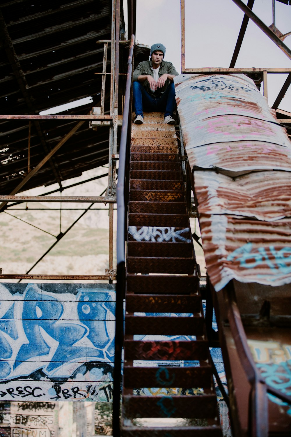 man sitting on stair during daytime