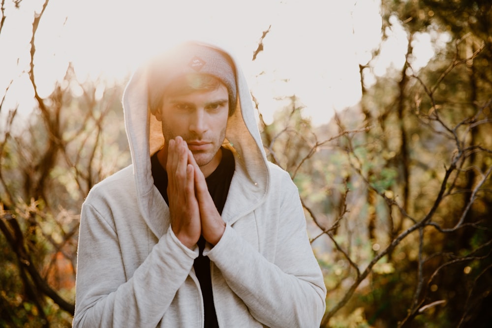 man in white hoodie near brown trees