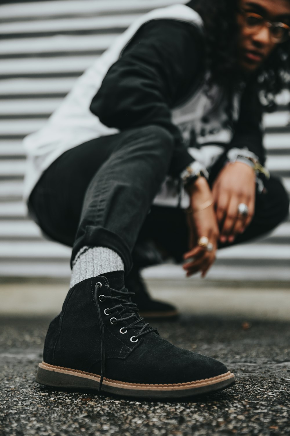 homme portant un sweat-shirt noir et gris agenouillé sur le sol