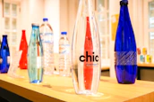 A lineup of elegant, personalized glass bottles displayed on a wooden table.